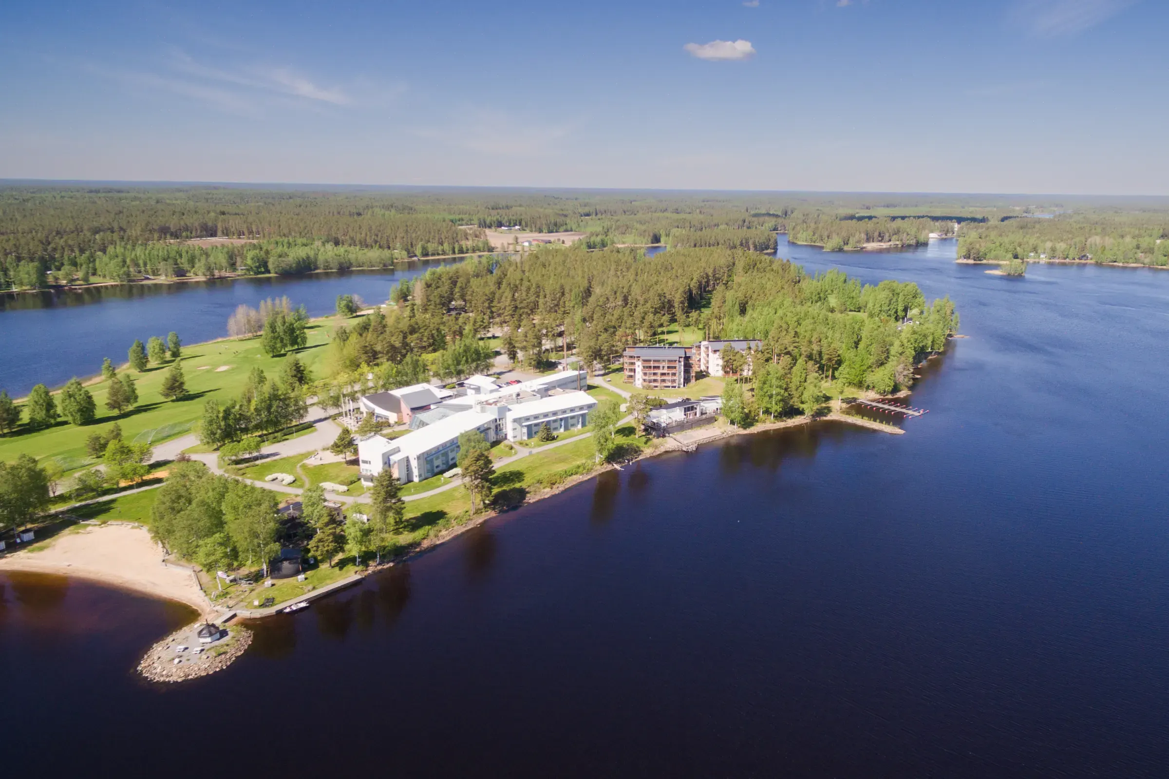 Ilmakuva Lodge Hotelin rakennuksista järven rannalla kesällä